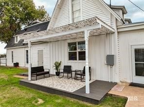 rear view of house with a pergola, a lawn, and a patio area