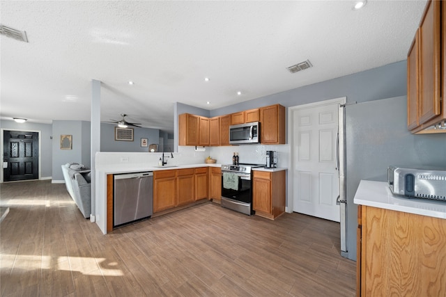 kitchen featuring ceiling fan, light hardwood / wood-style floors, sink, and stainless steel appliances