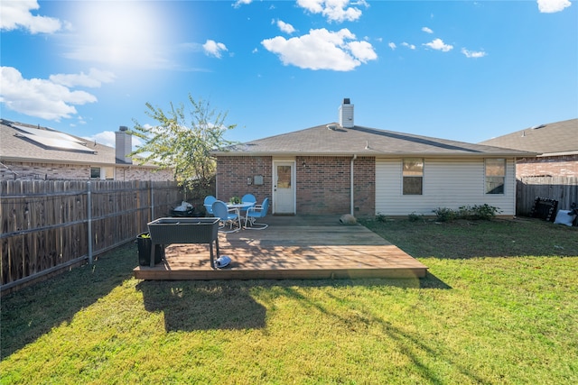 back of property with a yard and a deck