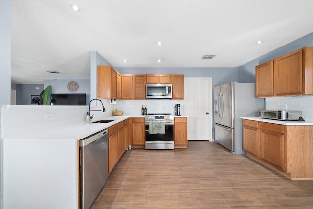 kitchen with light wood-type flooring, stainless steel appliances, and sink