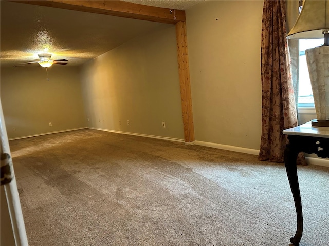 empty room featuring ceiling fan, lofted ceiling with beams, carpet floors, and a textured ceiling