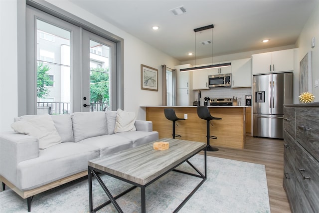 living room with light hardwood / wood-style flooring and sink