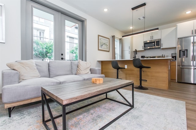 living room with sink and light wood-type flooring