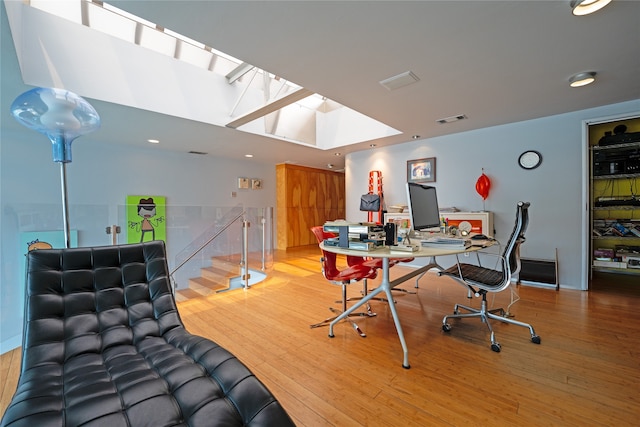 home office featuring hardwood / wood-style flooring and a skylight