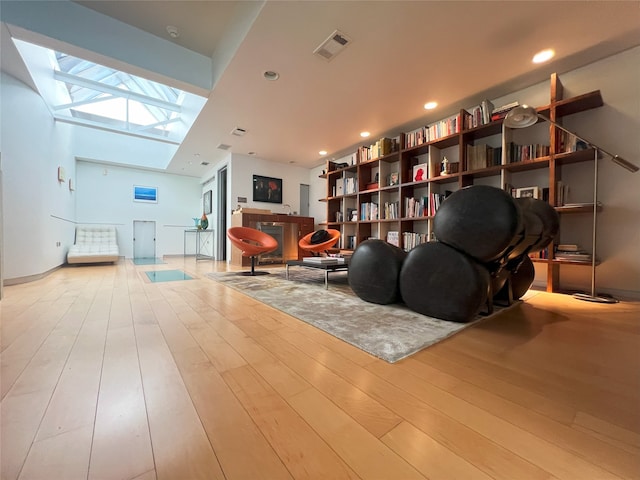 living area featuring light hardwood / wood-style flooring and a skylight