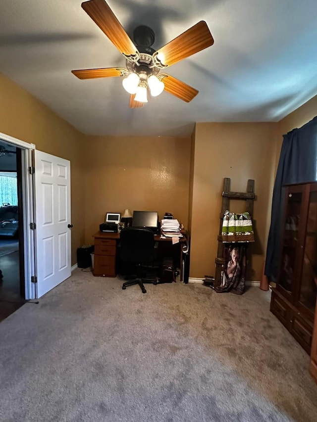 carpeted home office with a ceiling fan