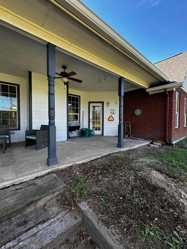 property entrance with brick siding, a patio area, and a ceiling fan