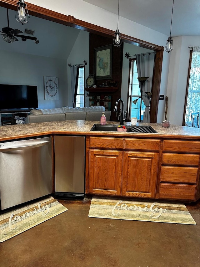 kitchen with hanging light fixtures, concrete floors, appliances with stainless steel finishes, and a sink