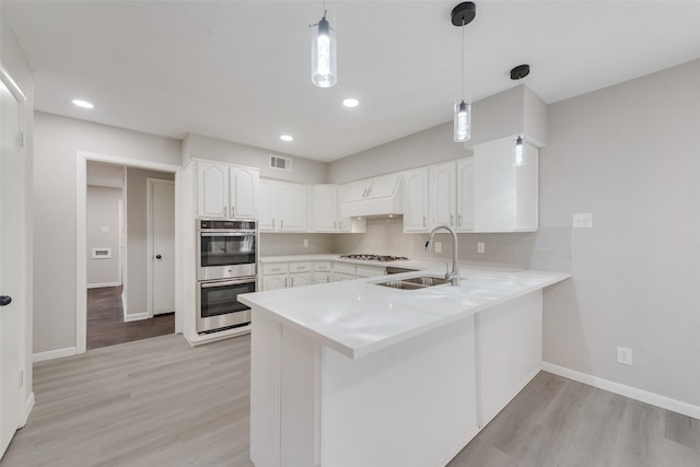 kitchen with stainless steel appliances, pendant lighting, sink, white cabinets, and kitchen peninsula