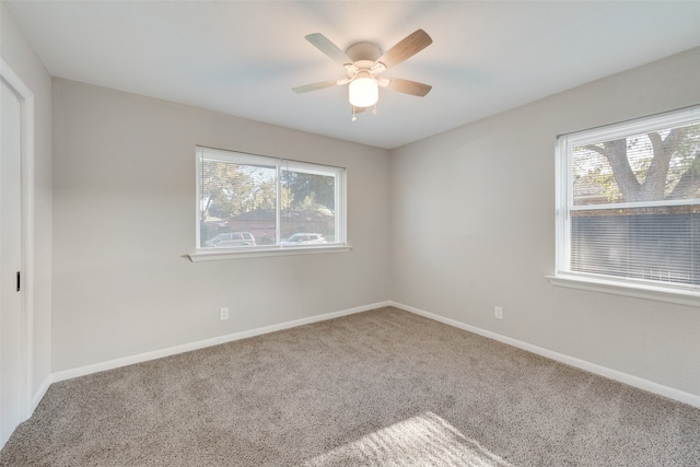 unfurnished room with carpet, a wealth of natural light, and ceiling fan