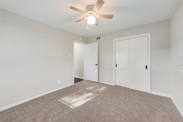 unfurnished bedroom featuring carpet, ceiling fan, and a closet