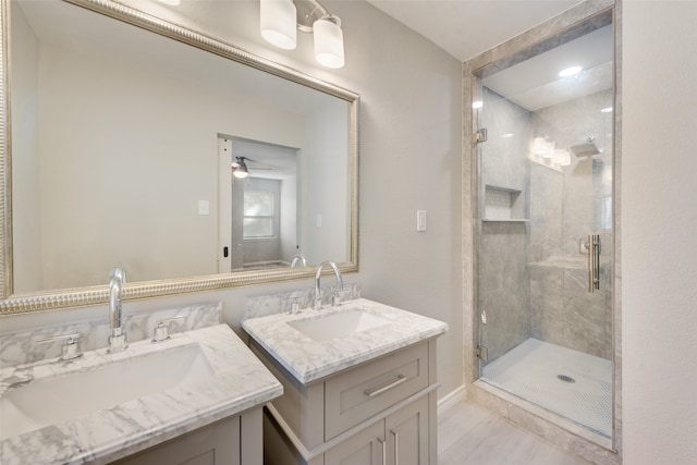 bathroom with vanity, ceiling fan, and a shower with shower door