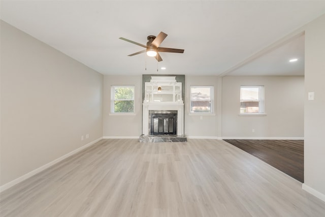 unfurnished living room with light wood-type flooring and ceiling fan