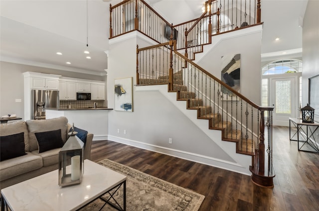 living room featuring ornamental molding, dark hardwood / wood-style flooring, and a high ceiling