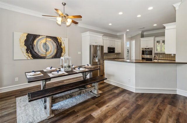 kitchen with tasteful backsplash, appliances with stainless steel finishes, dark hardwood / wood-style floors, and white cabinets