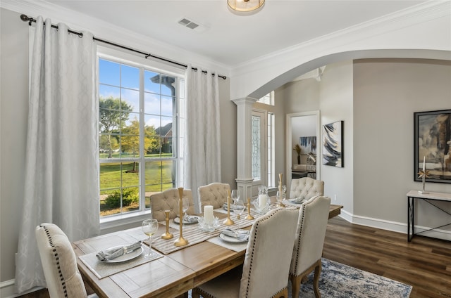 dining area with crown molding, a healthy amount of sunlight, dark hardwood / wood-style floors, and decorative columns