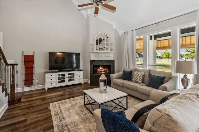 living room featuring dark wood-type flooring, ceiling fan, high vaulted ceiling, and crown molding