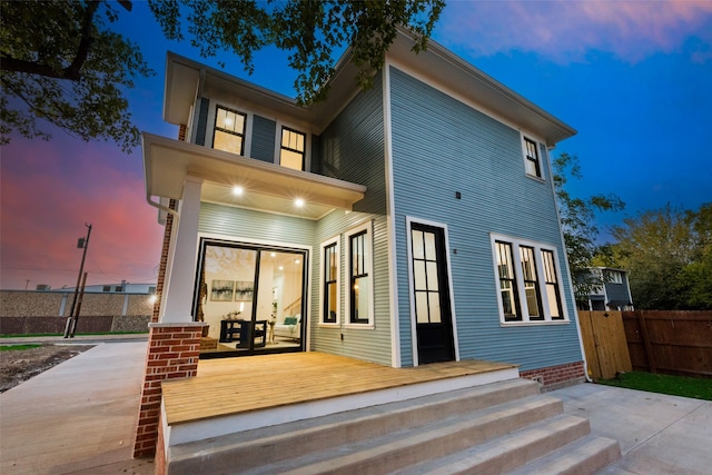 back house at dusk with a deck