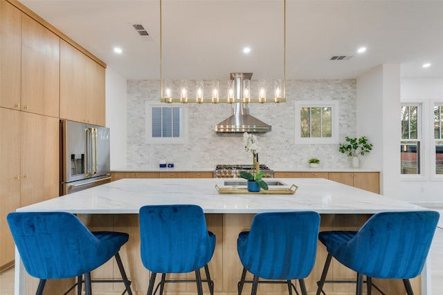 kitchen featuring a spacious island, pendant lighting, light brown cabinets, and stainless steel appliances