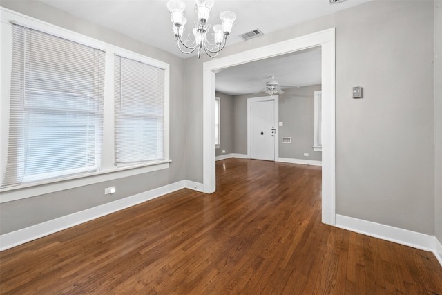 unfurnished dining area with dark hardwood / wood-style floors and ceiling fan with notable chandelier