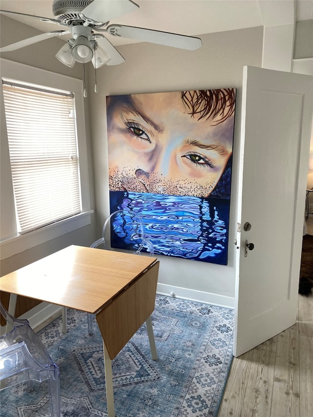 dining space with hardwood / wood-style flooring and ceiling fan