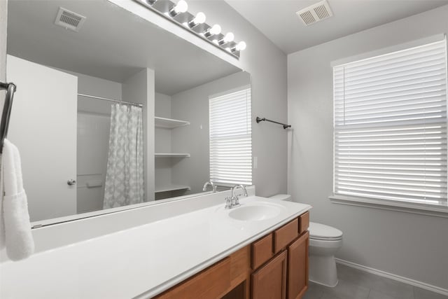 bathroom with a wealth of natural light, tile patterned flooring, vanity, and toilet