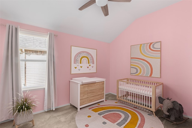 bedroom featuring ceiling fan, light colored carpet, a nursery area, and lofted ceiling