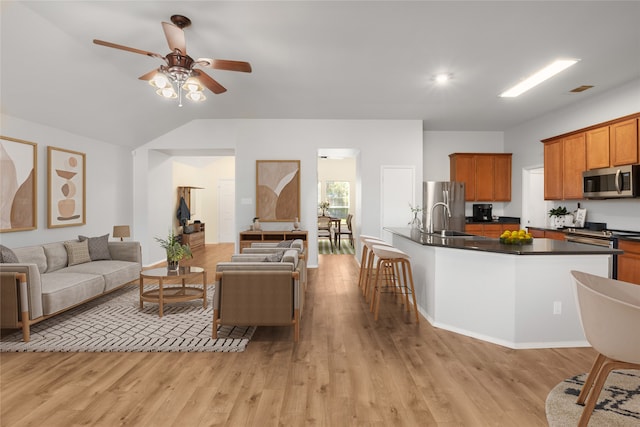 living room with light hardwood / wood-style flooring, ceiling fan, lofted ceiling, and sink