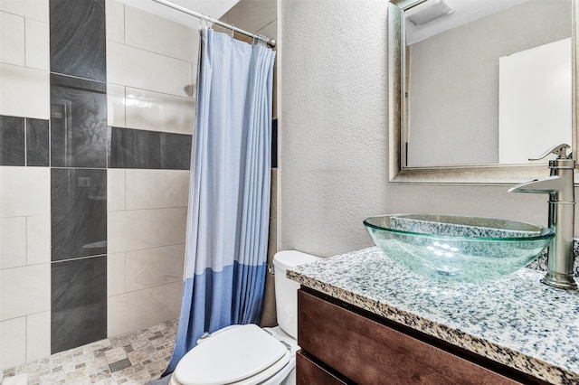 bathroom with toilet, vanity, and a shower with shower curtain