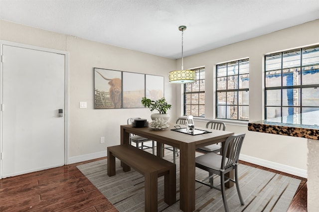 dining room with dark wood-type flooring and a textured ceiling