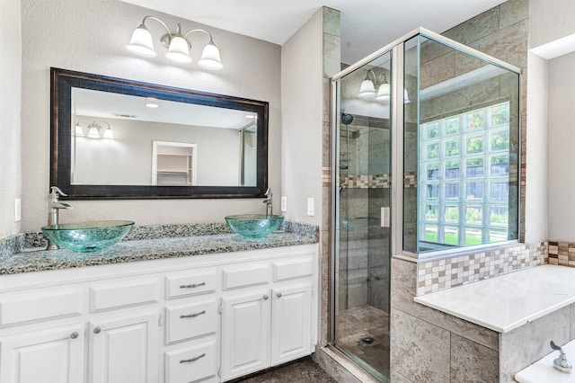 bathroom featuring a wealth of natural light, vanity, and separate shower and tub