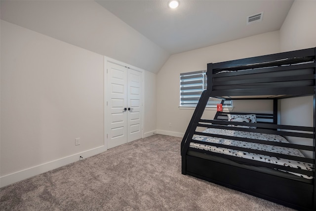 bedroom featuring carpet flooring, a closet, and vaulted ceiling