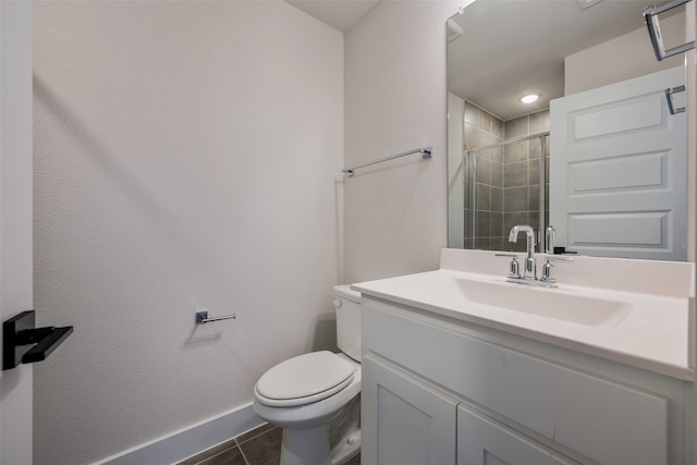 bathroom featuring toilet, vanity, tile patterned floors, and a shower with shower door