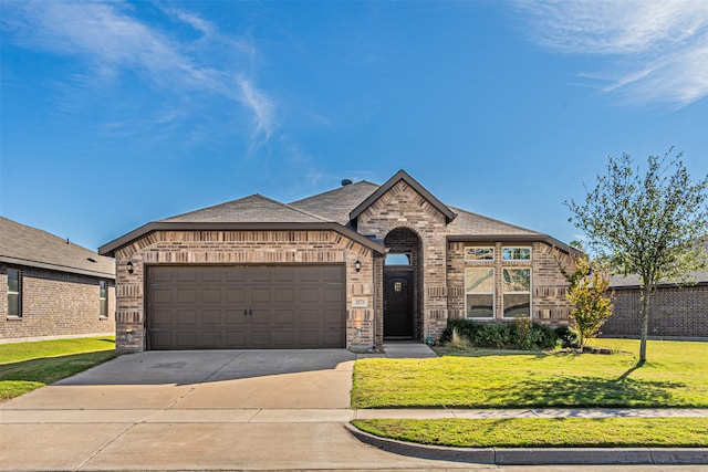 view of front of property featuring a front yard and a garage