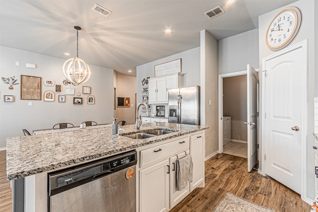 kitchen featuring stainless steel appliances, white cabinetry, dark hardwood / wood-style flooring, sink, and a kitchen island with sink