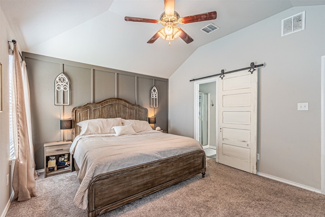 carpeted bedroom with lofted ceiling, a barn door, and ceiling fan