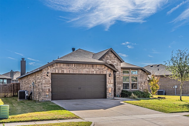 view of front facade with central AC unit, a garage, and a front lawn