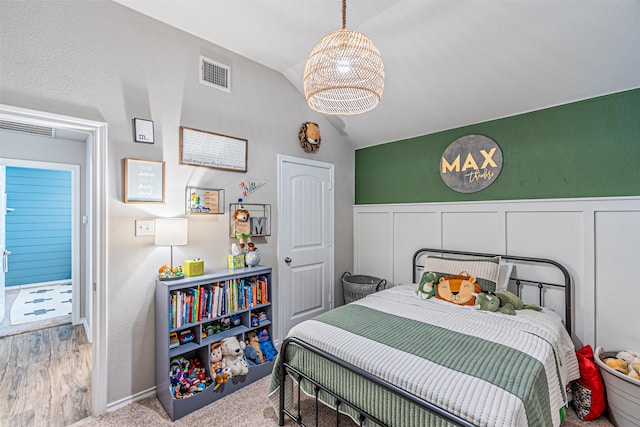 carpeted bedroom with lofted ceiling