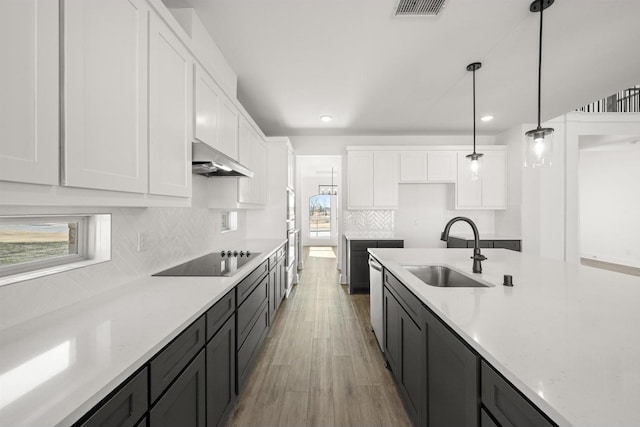 kitchen with pendant lighting, sink, white cabinetry, stainless steel appliances, and tasteful backsplash