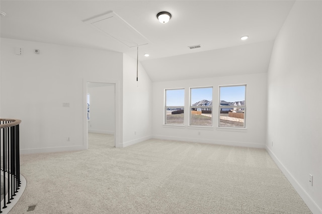 carpeted spare room featuring lofted ceiling