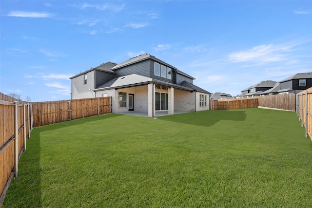 rear view of house featuring a yard and a patio