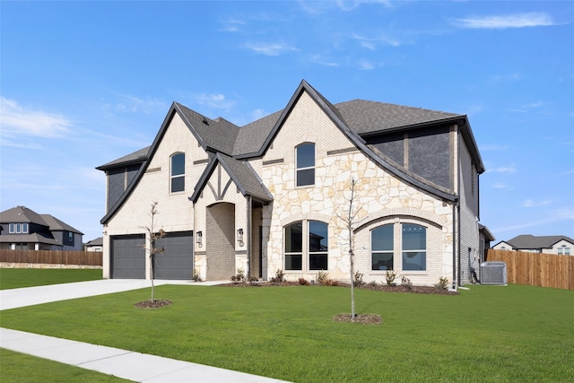 view of front of home with a garage, cooling unit, and a front lawn