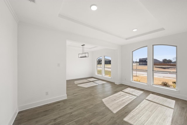 interior space featuring a tray ceiling, dark hardwood / wood-style floors, and a chandelier