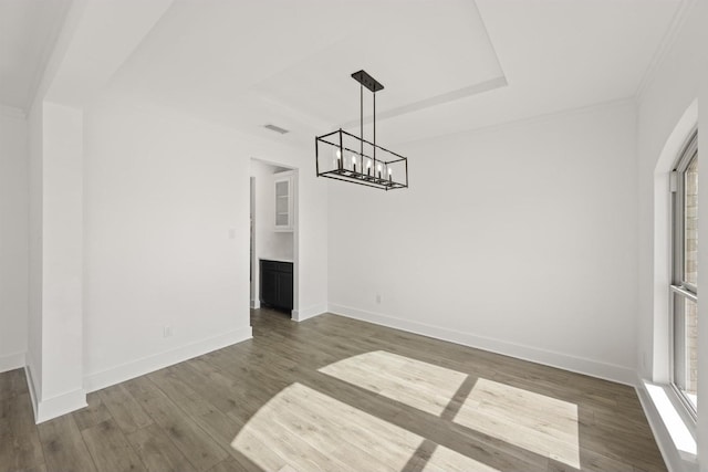 unfurnished dining area with a wealth of natural light, ornamental molding, and dark hardwood / wood-style floors