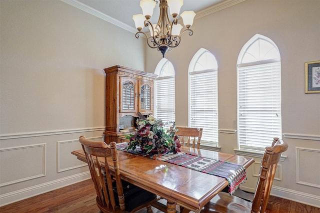 dining space featuring dark hardwood / wood-style flooring, an inviting chandelier, and ornamental molding