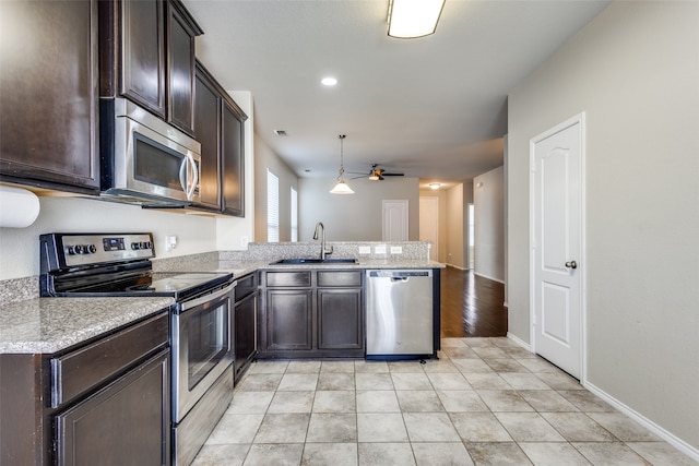 kitchen featuring stainless steel appliances, kitchen peninsula, sink, ceiling fan, and pendant lighting