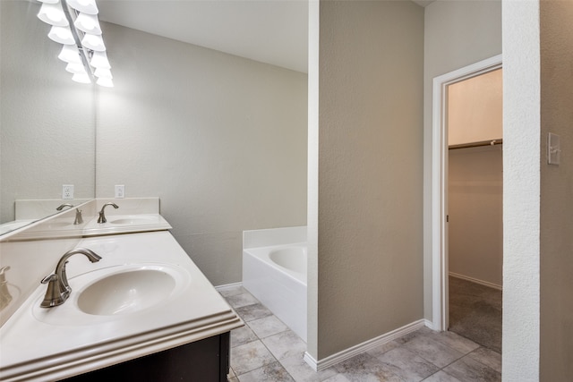 bathroom with vanity, a tub, and tile patterned floors