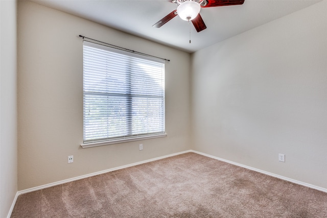 carpeted spare room with ceiling fan