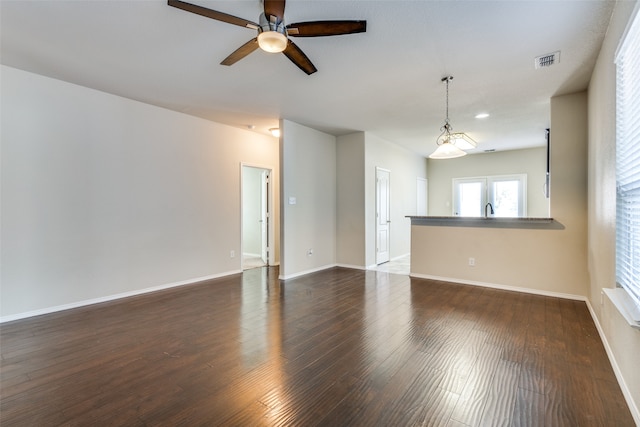 spare room featuring dark wood-type flooring and ceiling fan