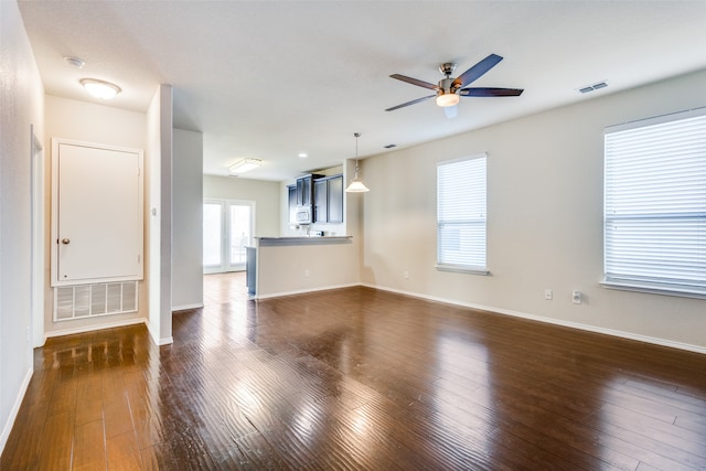 unfurnished living room with dark wood-type flooring and ceiling fan